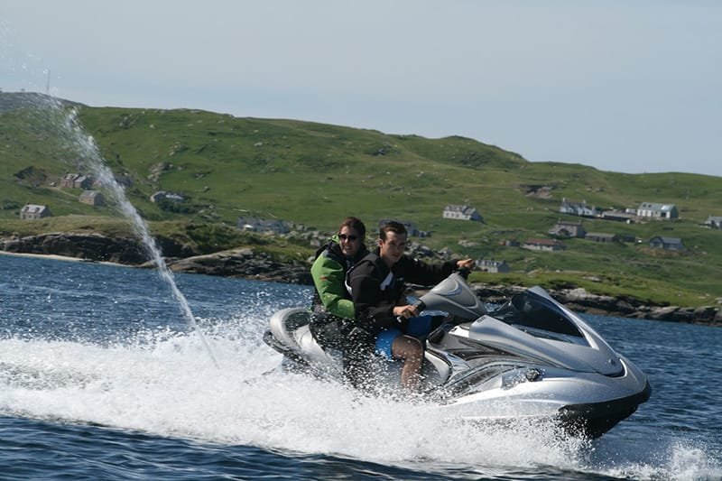 Two people flying along on a Jet Ski